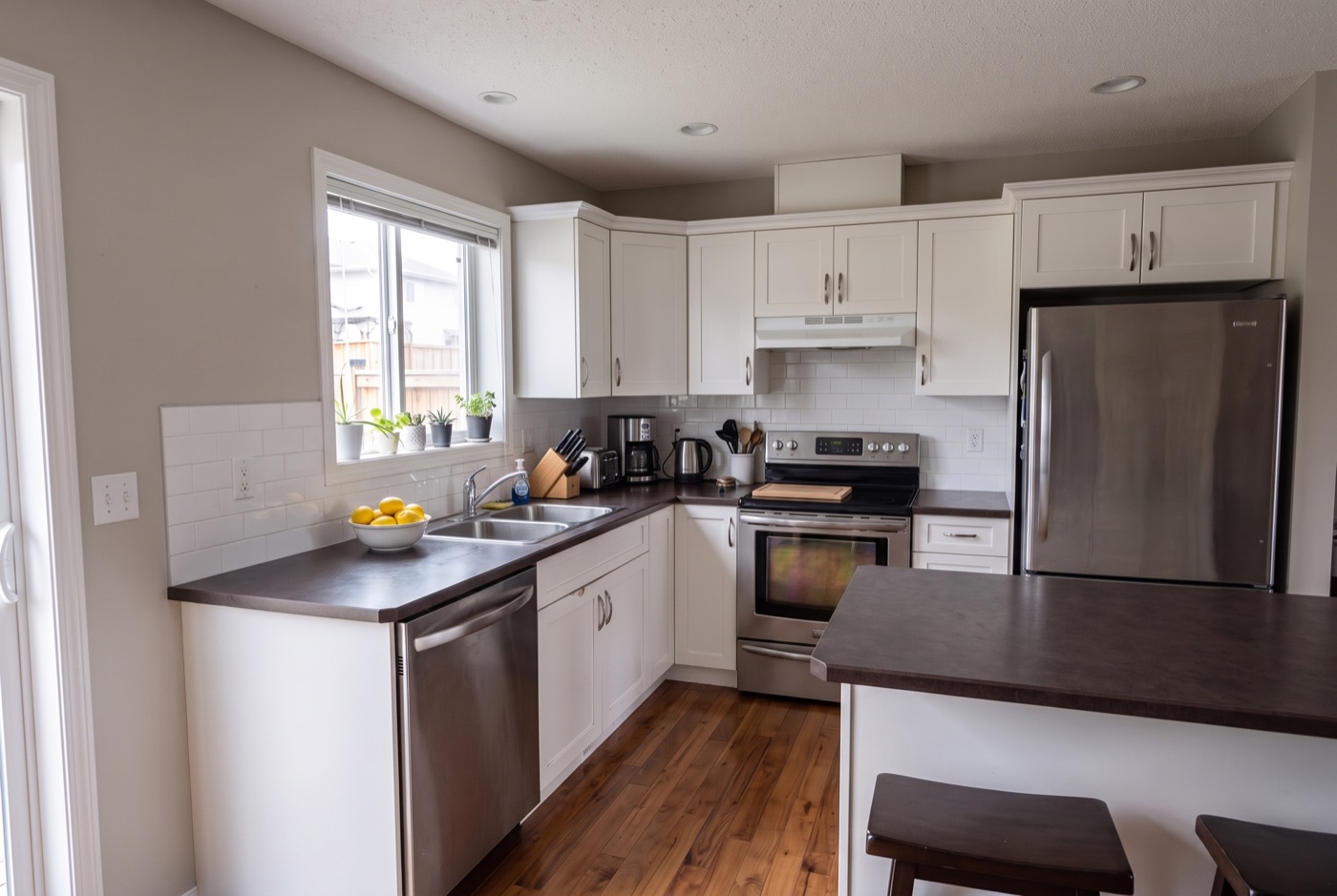 The same kitchen from the same angle with counters cleared and the fridge door bare