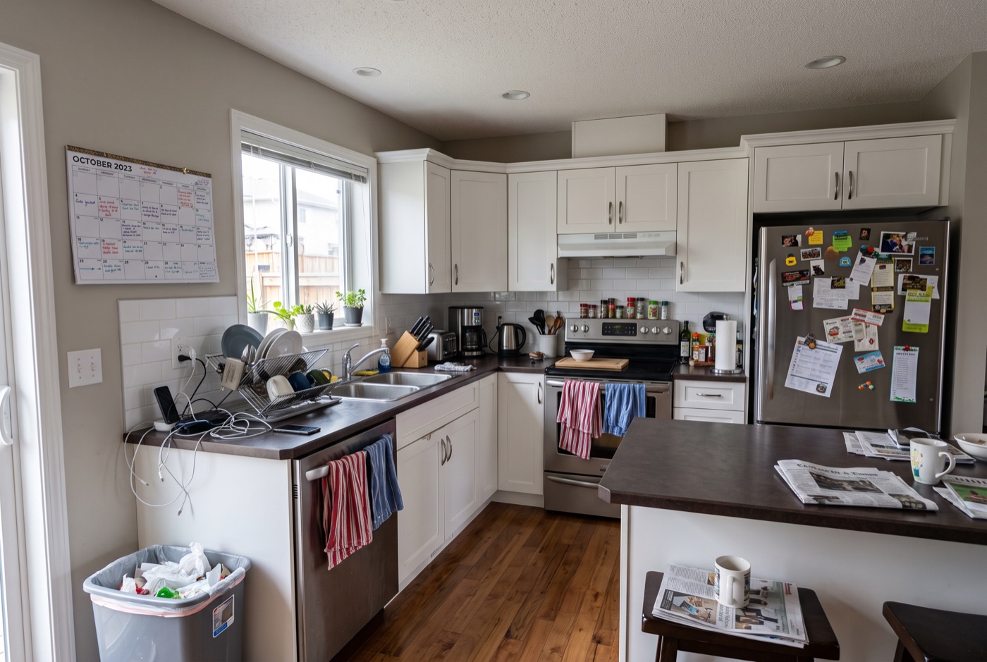A kitchen with appliances crowding the counter, a covered fridge door and cables visible